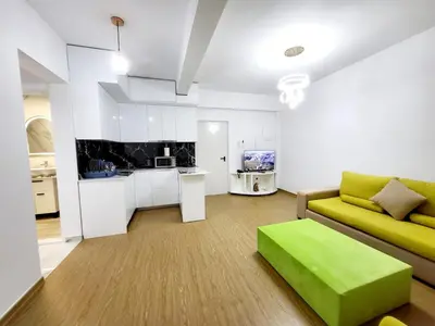 a living room with a yellow couch and a kitchen at AHAMED GREEK SMPCO in Athens