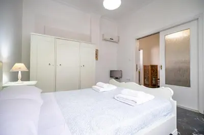 a white bedroom with two white towels on a bed at Keratsini 2 bedroom 4 pers apart by MPS in Piraeus