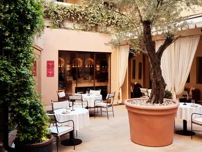 a restaurant with tables and a tree in a pot at The Margi in Athens