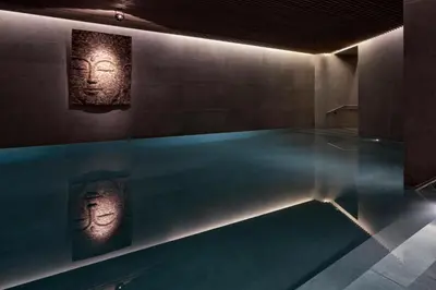 a swimming pool with two statues of faces on the wall at The Margi in Athens