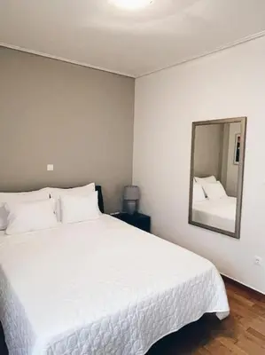 a bedroom with a large white bed and a mirror at CS Central Apartment in Athens