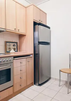 a kitchen with a stainless steel refrigerator and a table at CS Central Apartment in Athens