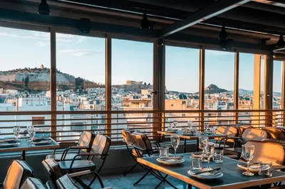 a restaurant with tables and chairs and a view of the city at Ilissos in Athens