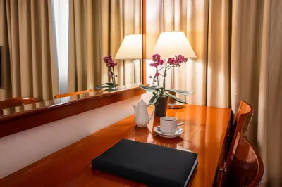 a table with a lamp and flowers on it at Ilissos in Athens