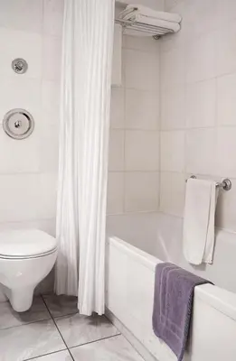 a white bathroom with a tub and a toilet at Ilissos in Athens