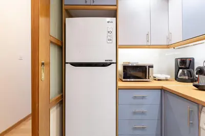 a white refrigerator in a kitchen with blue cabinets at Athenian Gate to Plaka by Athenian Homes in Athens