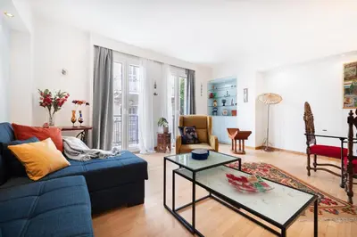 a living room with a blue couch and a table at Athenian Gate to Plaka by Athenian Homes in Athens
