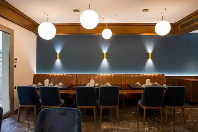 a long table in a room with chairs and lights at Delice Hotel - Family Apartments in Athens