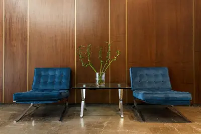 two blue chairs and a glass table with a vase at Delice Hotel - Family Apartments in Athens
