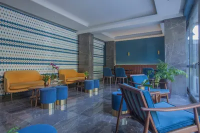 a waiting room with blue chairs and tables at Delice Hotel - Family Apartments in Athens