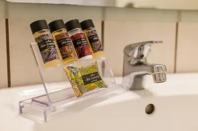 a sink with three bottles of toothpaste and a faucet at Delice Hotel - Family Apartments in Athens