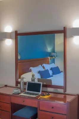 a bedroom with a bed and a desk with a laptop at Delice Hotel - Family Apartments in Athens