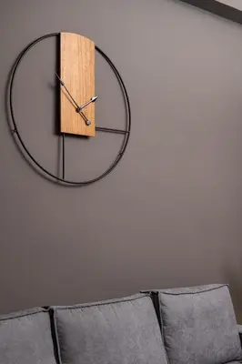 a clock hanging on a wall next to a couch at Acropolis Amazing View: One-Bedroom Gem in Athens