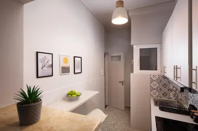 a kitchen with a table and a sink and a refrigerator at Acropolis Amazing View: One-Bedroom Gem in Athens
