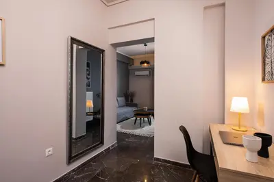 a room with a mirror and a desk with a chair at Acropolis Amazing View: One-Bedroom Gem in Athens
