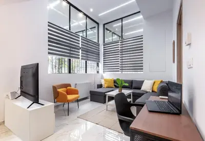 a living room with a couch and a tv at LIV - Modern Spacious Apartment in Gazi in Athens