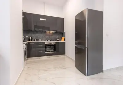 a kitchen with a stainless steel refrigerator at LIV - Modern Spacious Apartment in Gazi in Athens
