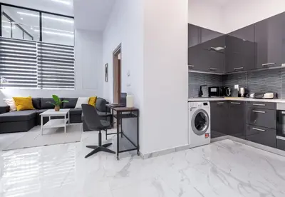 a kitchen and living room with a washer and dryer at LIV - Modern Spacious Apartment in Gazi in Athens