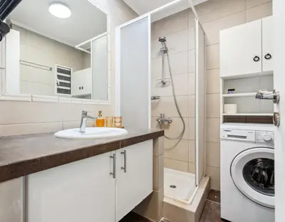 a bathroom with a sink and a washing machine at Two-Bedroom Apartment in Pagrati in Athens