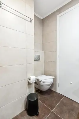 a bathroom with a toilet and a trash can at Two-Bedroom Apartment in Pagrati in Athens