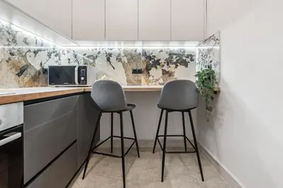 a kitchen with two stools at a counter at Two-Bedroom Apartment in Pagrati in Athens