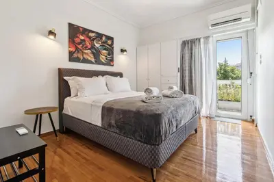 a bedroom with a bed and a large window at Two-Bedroom Apartment in Pagrati in Athens