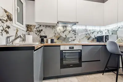a kitchen with white cabinets and a sink and a stove at Two-Bedroom Apartment in Pagrati in Athens