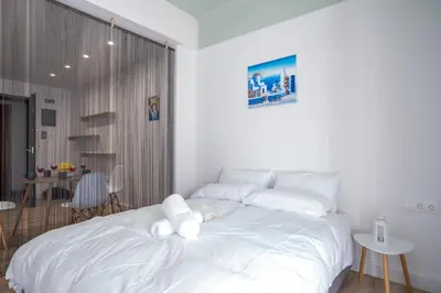 a white bed with a stuffed animal laying on it at \u8212\u9002\u6f02\u4eae\u7684\u4f11\u95f2\u516c\u5bd3 in Athens