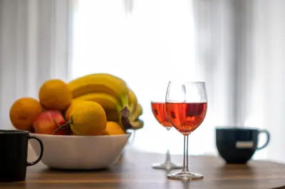a bowl of fruit and a glass of wine on a table at \u8212\u9002\u6f02\u4eae\u7684\u4f11\u95f2\u516c\u5bd3 in Athens