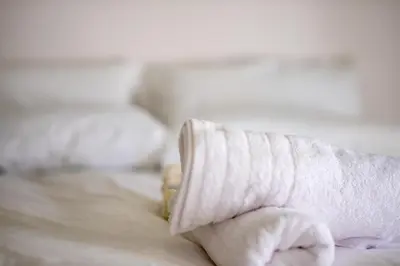 a person holding a wrapped sock on a bed at \u8212\u9002\u6f02\u4eae\u7684\u4f11\u95f2\u516c\u5bd3 in Athens
