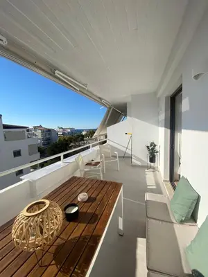 a living room with a wooden table on a balcony at Aphrodite Suite byArtistUnknown in Vari