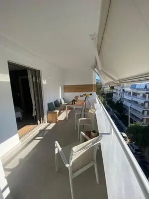 a balcony with white chairs and a living room at Aphrodite Suite byArtistUnknown in Vari