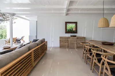 a living room with a long couch and wooden tables at Greece Dream Holidays Villas 1 in Athens