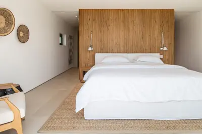 a bedroom with a white bed and a wooden wall at Greece Dream Holidays Villas 1 in Athens
