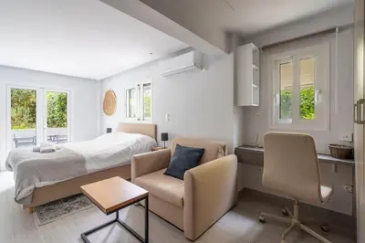 a bedroom with a bed and a table and chairs at Bright & Breezy Glyfada Studio in Athens
