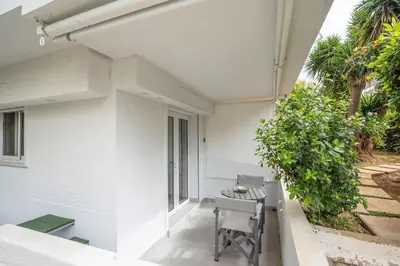a balcony with a chair and a table on a building at Bright & Breezy Glyfada Studio in Athens