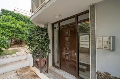 a door of a building with a plant next to it at Bright & Breezy Glyfada Studio in Athens