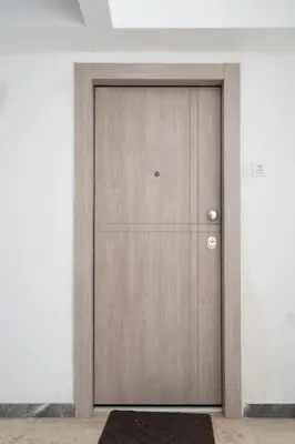 a wooden door in a room with a rug at Bright & Breezy Glyfada Studio in Athens