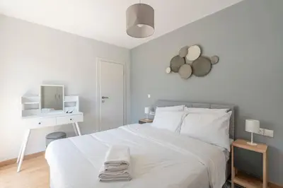 a white bedroom with a white bed and a desk at Tranquil Voula Getaway, A Calm Retreat in Voula in Athens