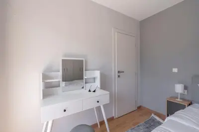 a white bedroom with a white dresser and a mirror at Tranquil Voula Getaway, A Calm Retreat in Voula in Athens