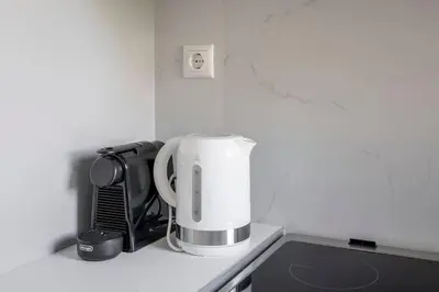 a white appliance sitting on top of a kitchen counter at Tranquil Voula Getaway, A Calm Retreat in Voula in Athens
