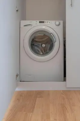 a washing machine in a room with a wooden floor at Tranquil Voula Getaway, A Calm Retreat in Voula in Athens
