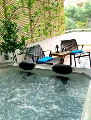 a swimming pool with chairs and a table and water at Vouliagmeni Seaside Luxury Home in Athens
