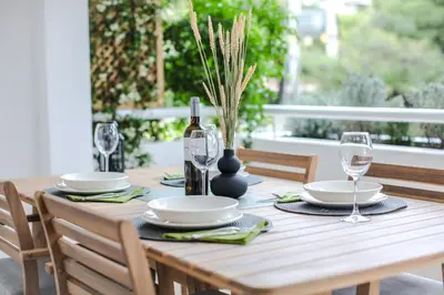 a wooden table with a bottle of wine and glasses at Vouliagmeni Seaside Luxury Home in Athens