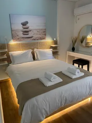 a bedroom with a large white bed with towels on it at Vouliagmeni Seaside Luxury Home in Athens
