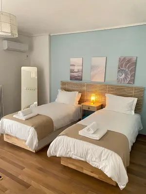 two beds sitting next to each other in a room at Vouliagmeni Seaside Luxury Home in Athens