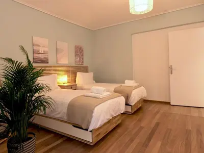 a bedroom with two beds and a potted plant at Vouliagmeni Seaside Luxury Home in Athens