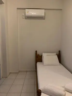 a small room with two beds and a air conditioner at Vasiliki’s Guesthouse II in Athens