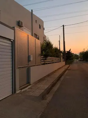 an empty street next to a building with a fence at Vasiliki’s Guesthouse II in Athens