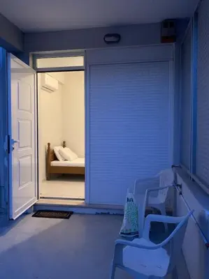 a room with a door and a bedroom with a bed at Vasiliki’s Guesthouse II in Athens